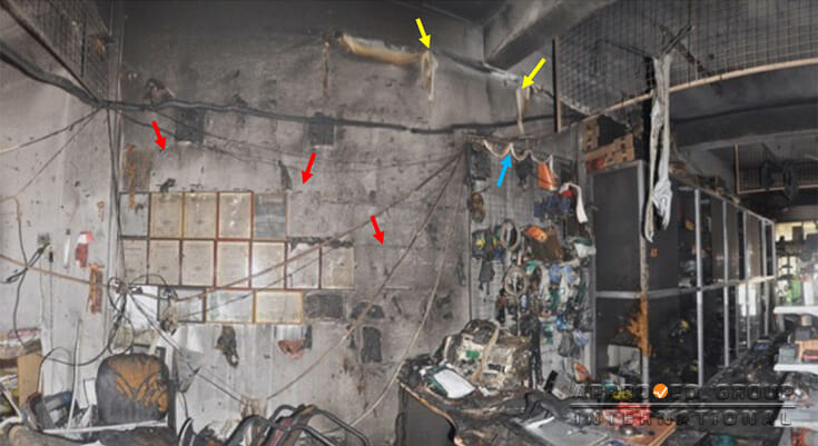 Photograph 1: The rear section of SL1; elevated fire damage was seen in this area as the plastic components that were hang for decoration were melted (yellow arrows), frames and posters located on a higher level were ignited and dropped down (red arrows).