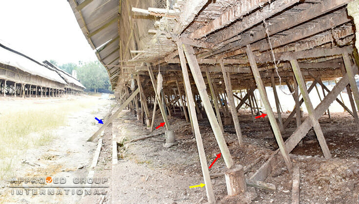 Figure 5: Panoramic view shows severe slanting of columns (red arrows), ‘L’-shaped lumber member (yellow arrow) affixed adjacent to the existing columns, and diagonally-placed lumber supports (blue arrow) which are anchored.
